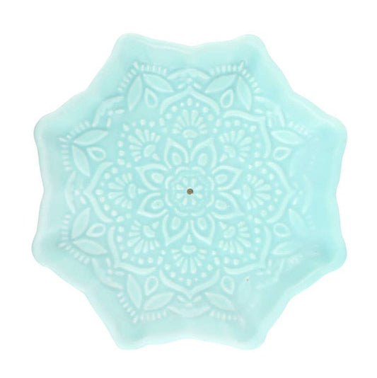 Light blue hexagonal coaster with intricate patterns on a white background