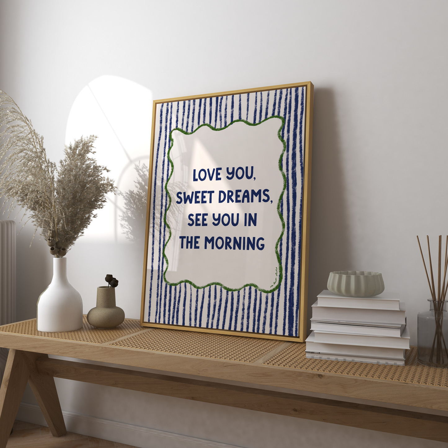 Framed artwork with motivational quote on a wooden console table.