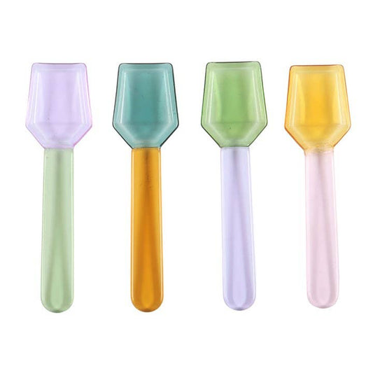 Four colourful glass spoons on a white background