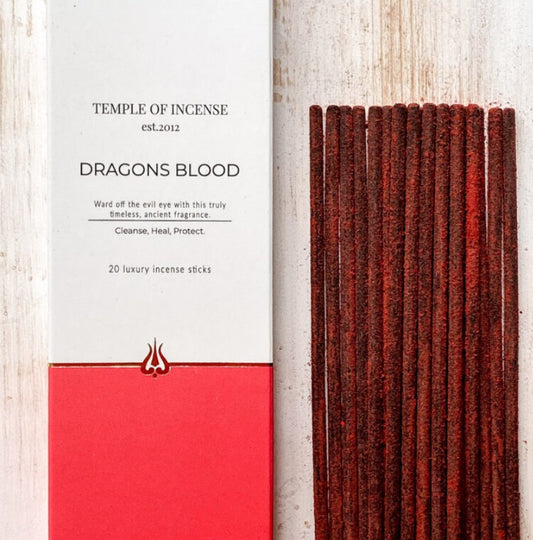 Incense sticks with packaging labeled 'Temple of Incense Dragons Blood' on a light wooden background