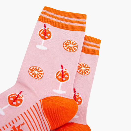 Pink socks with orange and white patterns on a white background