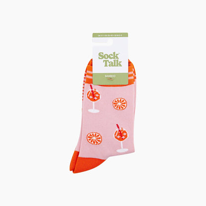 Packaged pink socks with orange designs and red toes on a white background