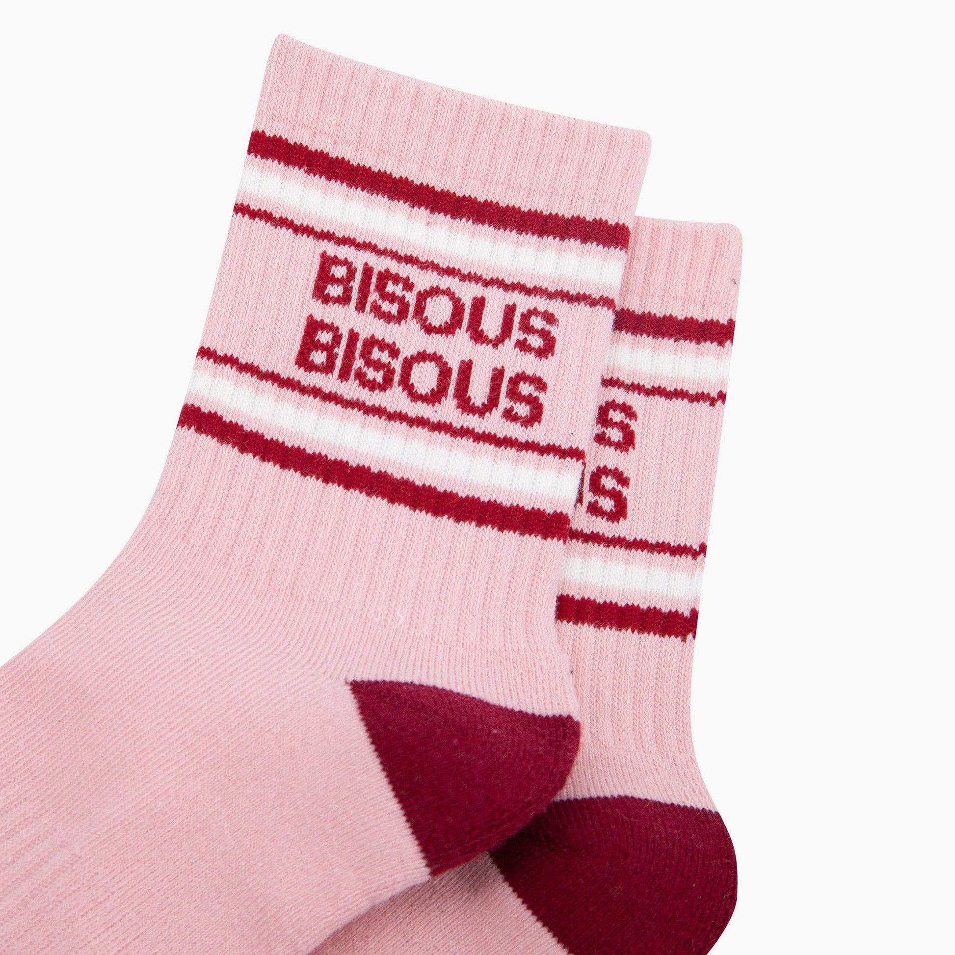 Pink socks with red and white striped pattern and 'BISOUS' text on a white background