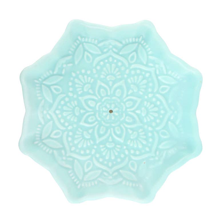 Light blue hexagonal coaster with intricate patterns on a white background