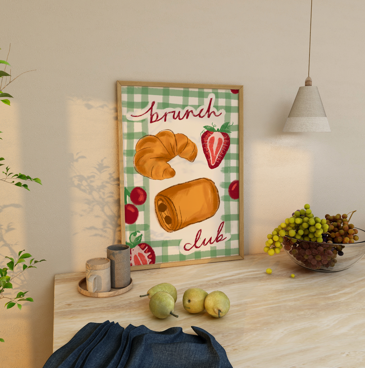 Framed artwork with 'Brunch Club' design on a table with fruits and decor.