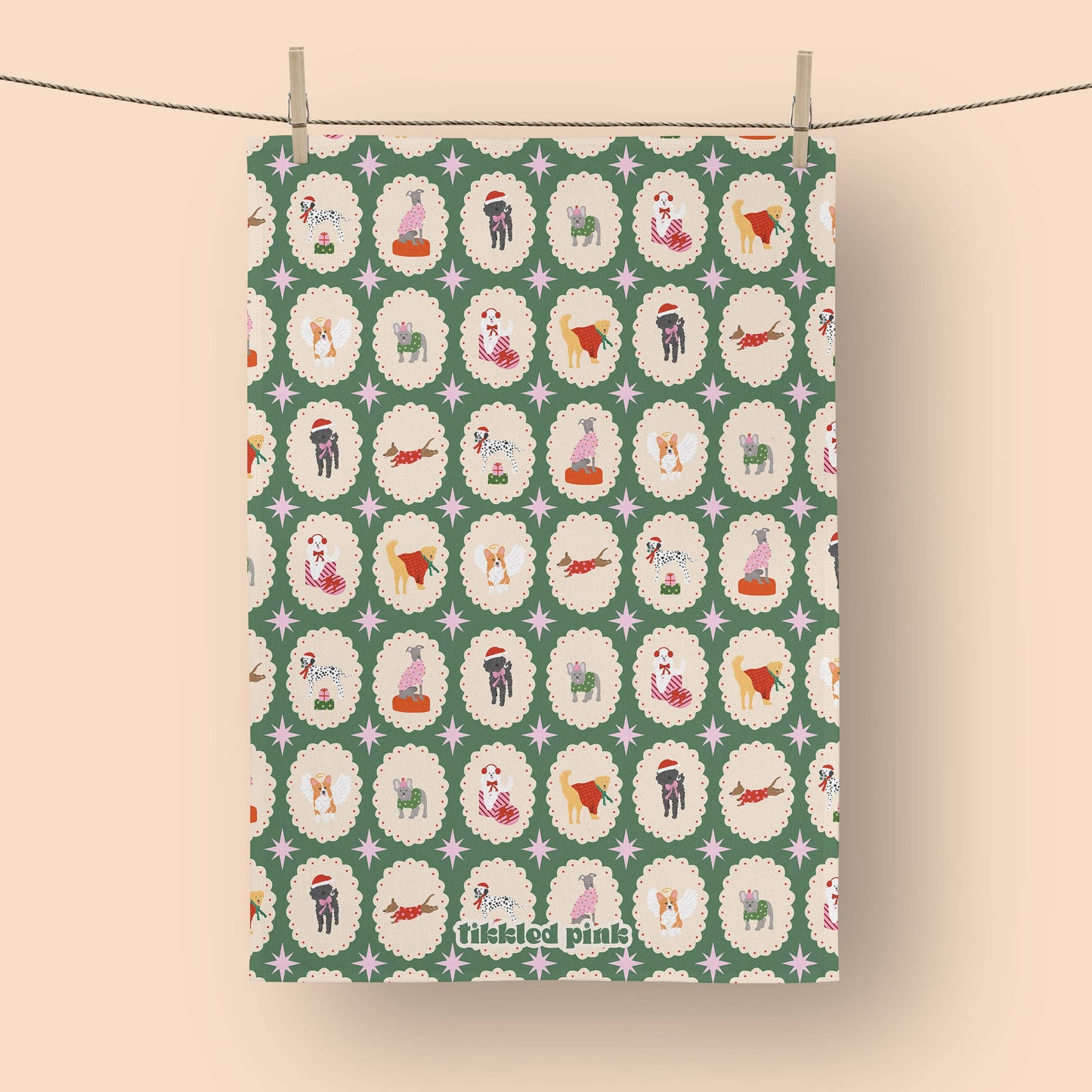 Patterned fabric with cartoon dogs on a green background, hanging on a line.