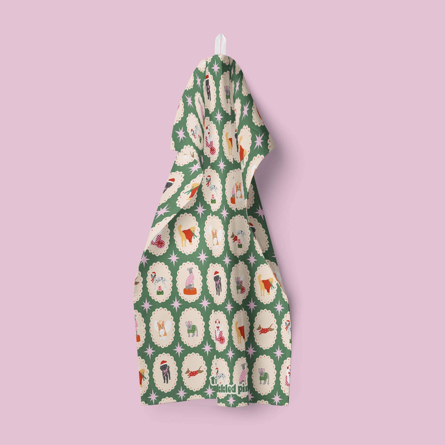 Green tea towel with a pattern of dogs on a pink background