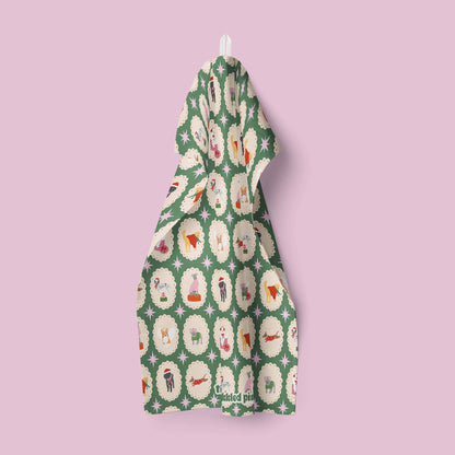 Green tea towel with a pattern of dogs on a pink background
