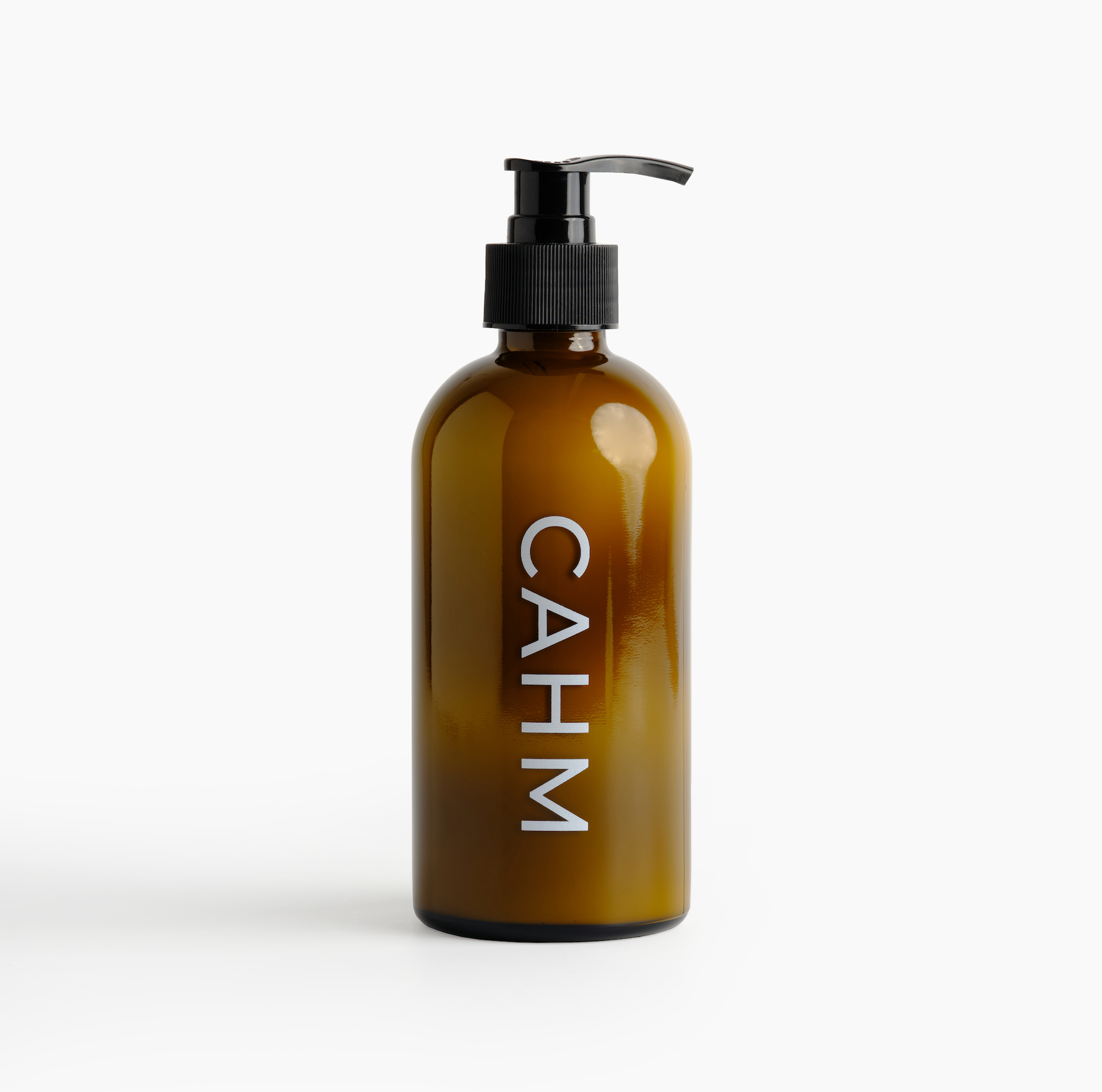 Amber glass bottle with pump and 'CAHM' label on a white background