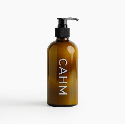 Amber glass bottle with pump and 'CAHM' label on a white background
