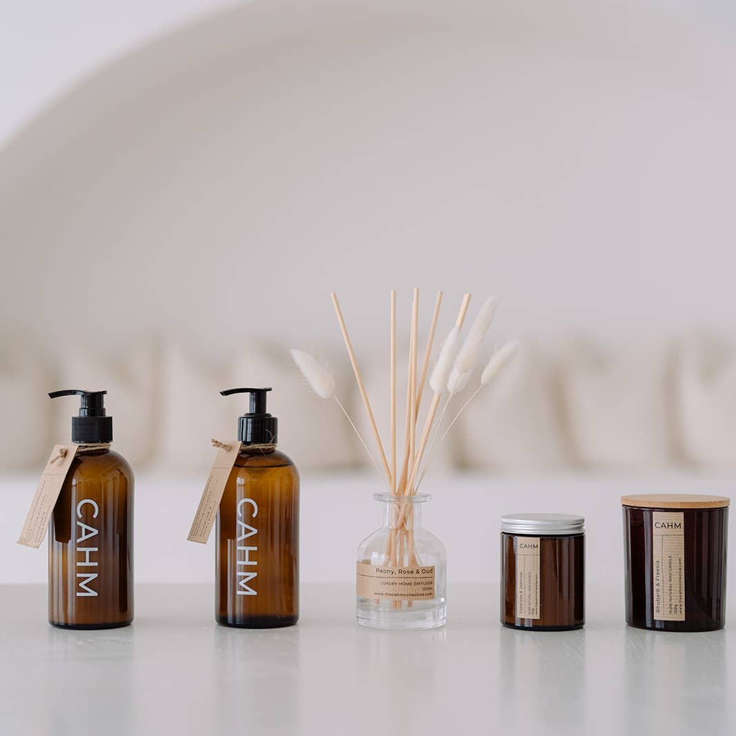 Collection of CAHM products including bottles and a diffuser on a light surface.