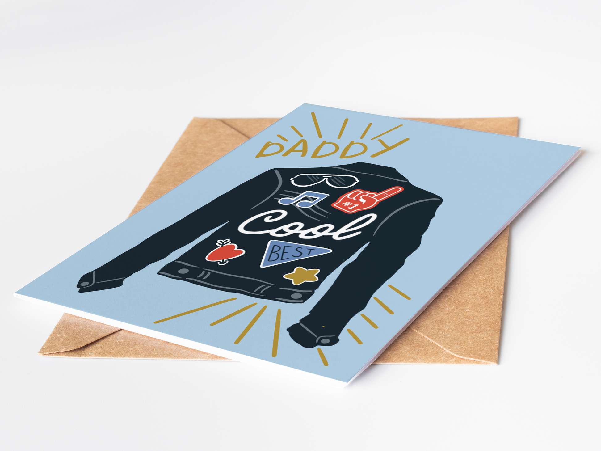 Greeting card with a graphic of a shirt and text 'Daddy Cool' on a blue background, with a brown envelope.