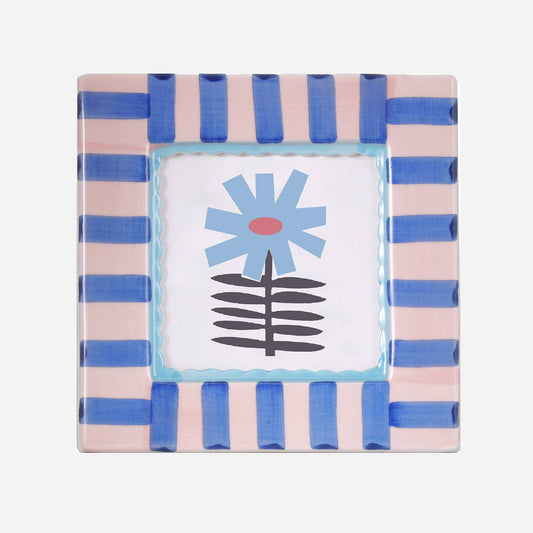 Decorative frame with pink and blue striped border featuring a central floral design.