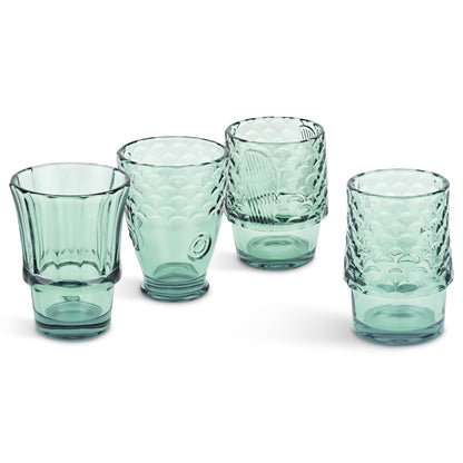 Set of five green glass tumblers with textured design on a white background