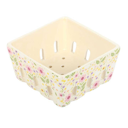 Beige plastic basket with floral pattern on a white background