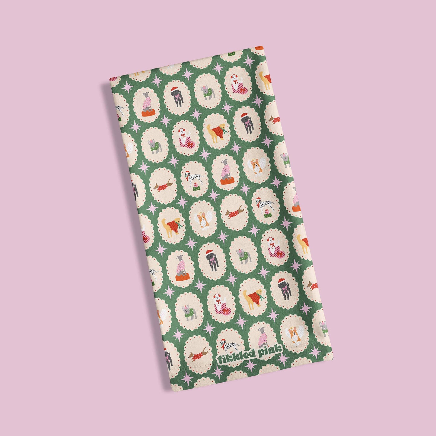 Folded green fabric with dog pattern on a light pink background