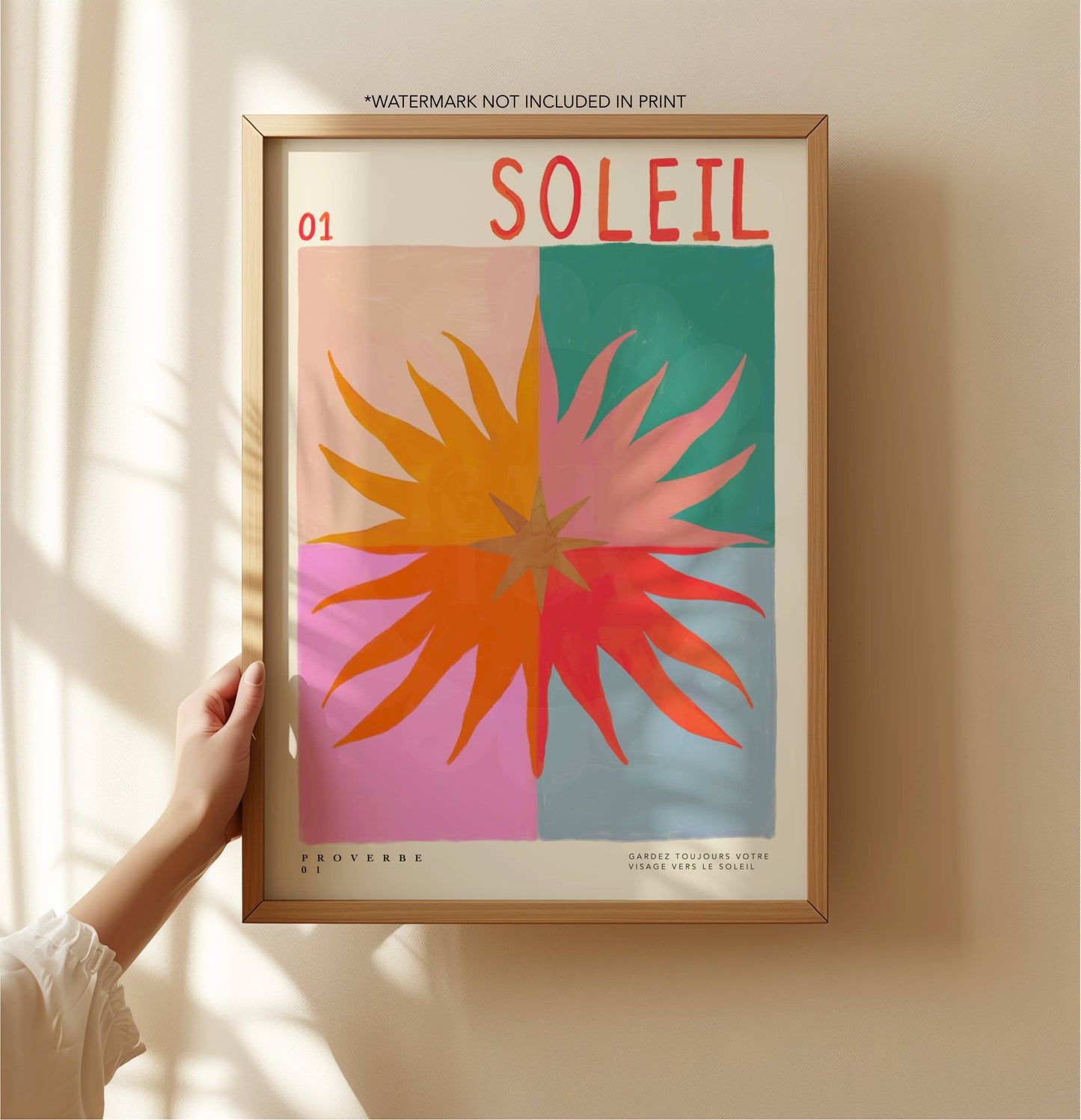 Framed artwork with a colorful abstract design and 'Soleil' text on a beige wall.