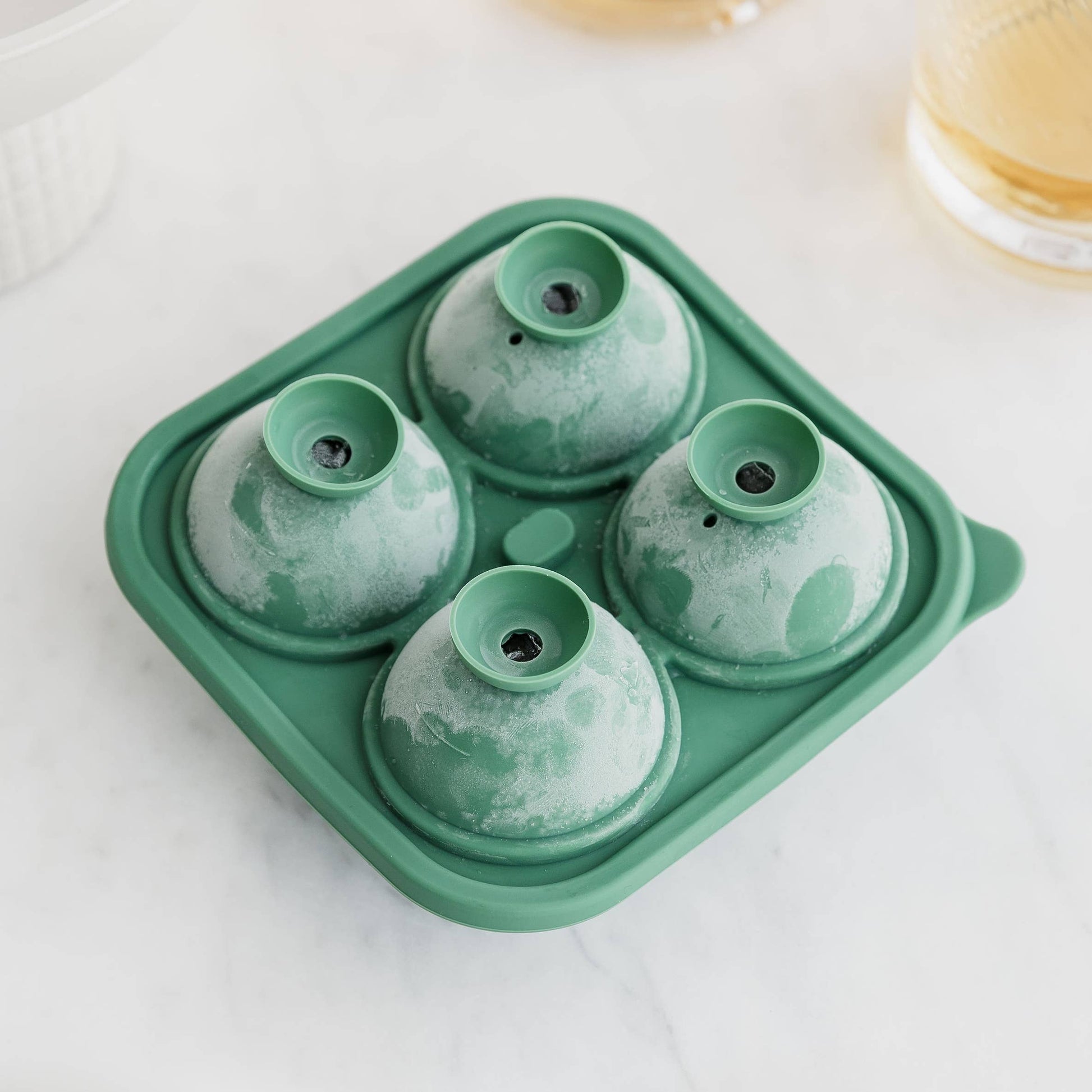 Green silicone ice mold tray on a white surface