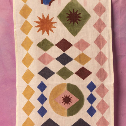 Geometric patterned fabric with colorful diamond shapes on a pink background