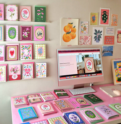 Desk with computer and various greeting cards on a wall