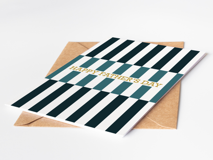 Greeting card with green and white striped design and 'Happy Father's Day' text, accompanied by a brown envelope on a light gray background.