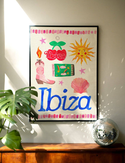 Framed artwork with 'Ibiza' and various icons on a wall with a plant and disco ball in the foreground.