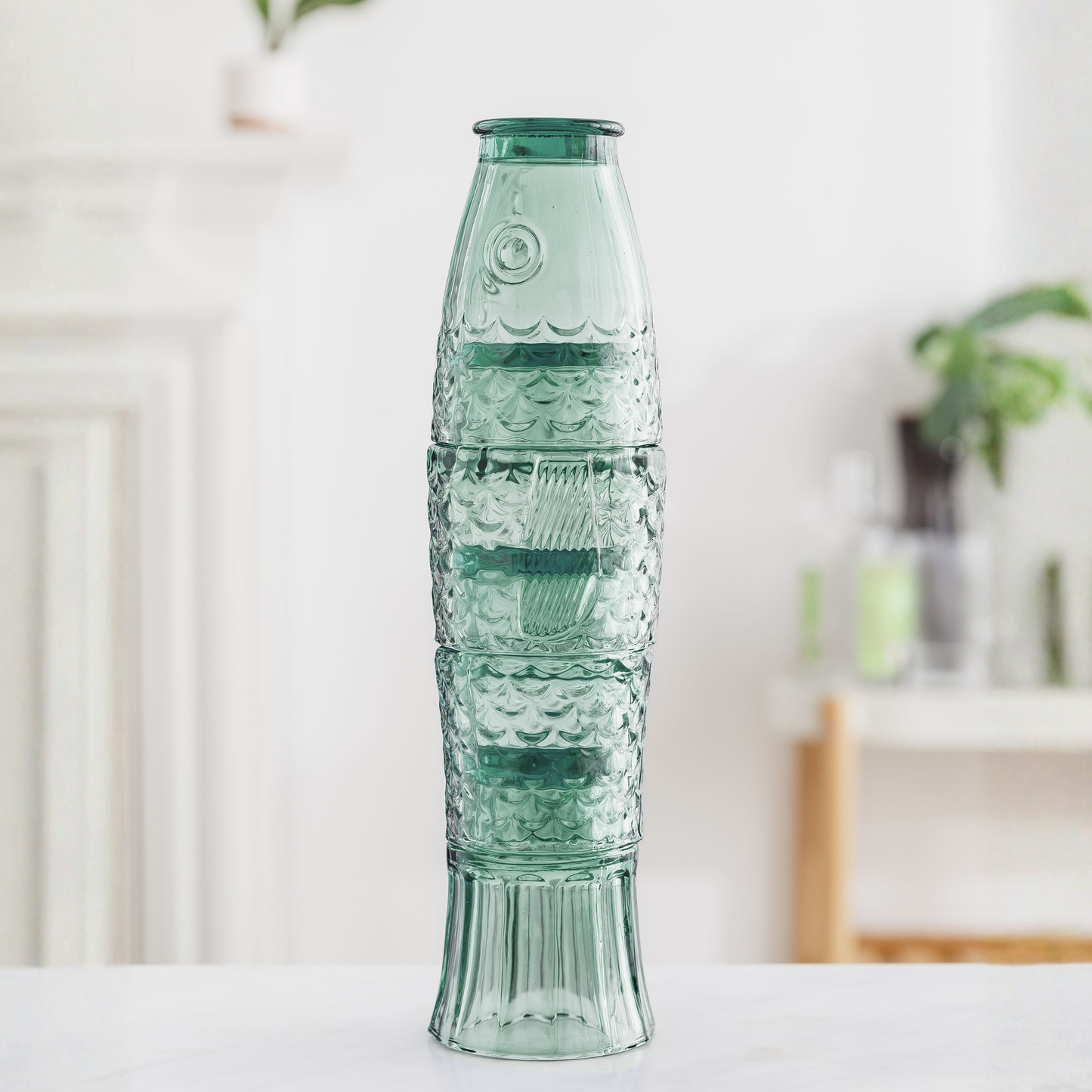 Image of green tumblers stacked together that create the shape of a fish