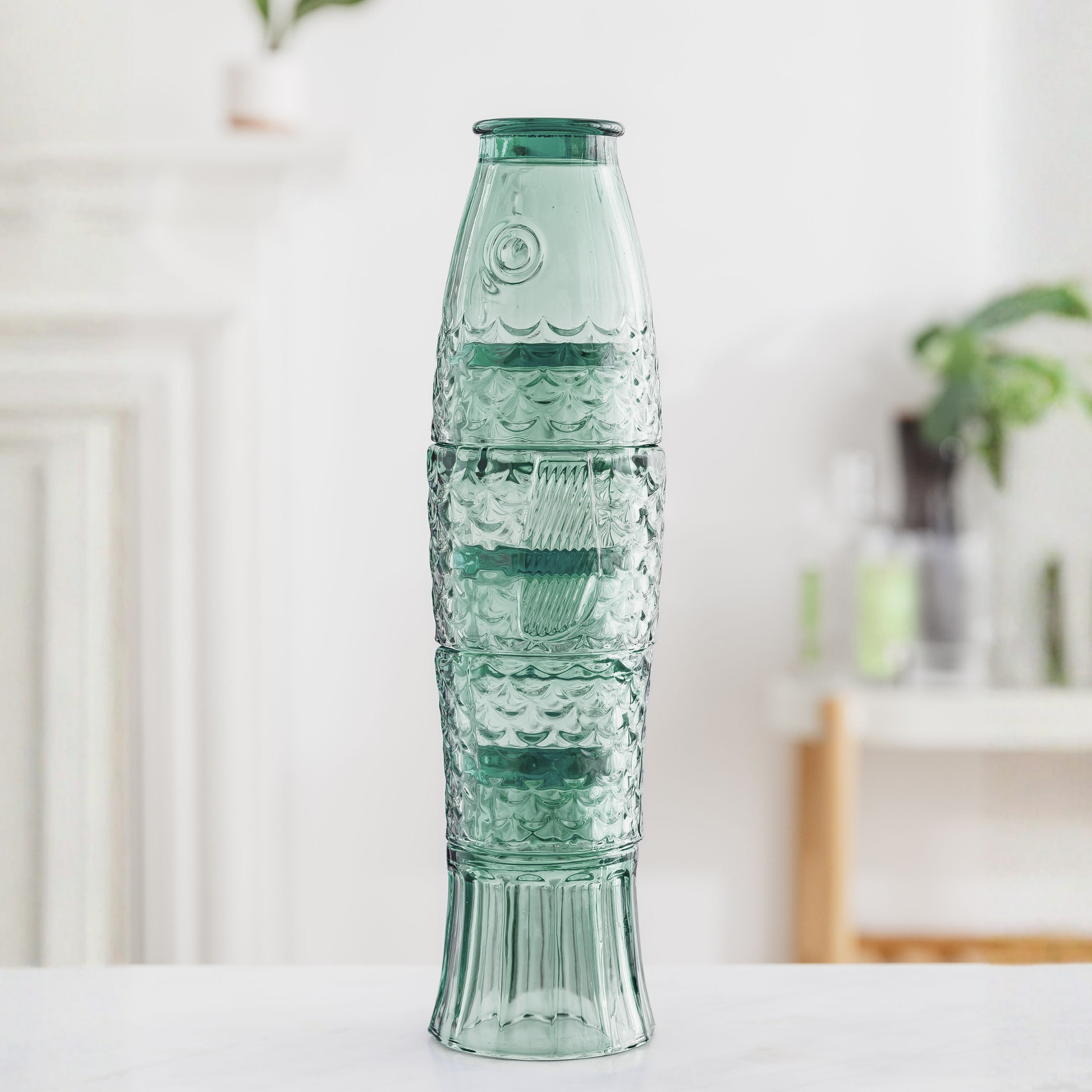 Image of green tumblers stacked together that create the shape of a fish