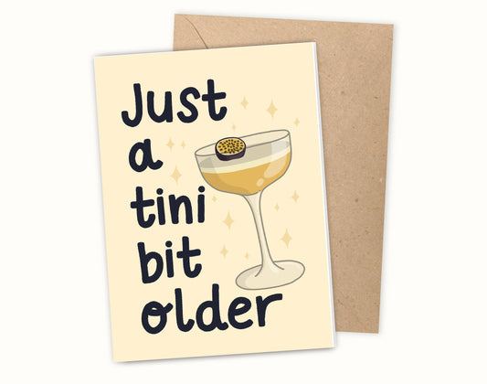 Greeting card with a cocktail illustration and text 'Just a tini bit older' on a white background.