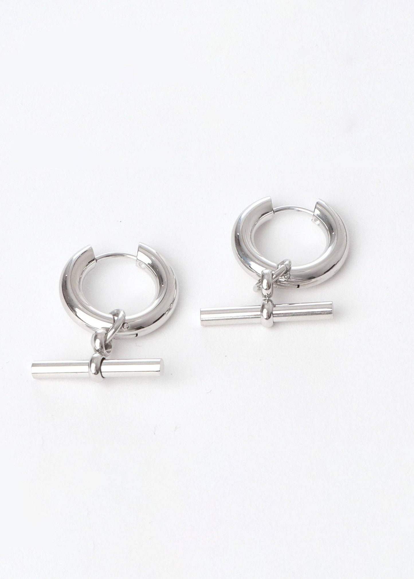 Pair of silver hoop earrings with horizontal bars on a white background