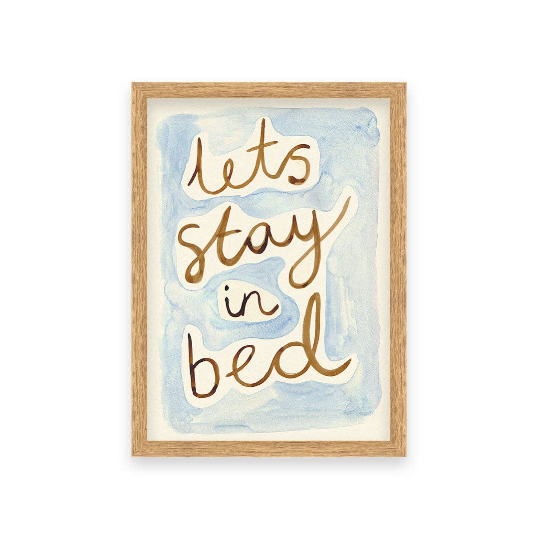 Framed artwork with 'let's stay in bed' text on a watercolor background