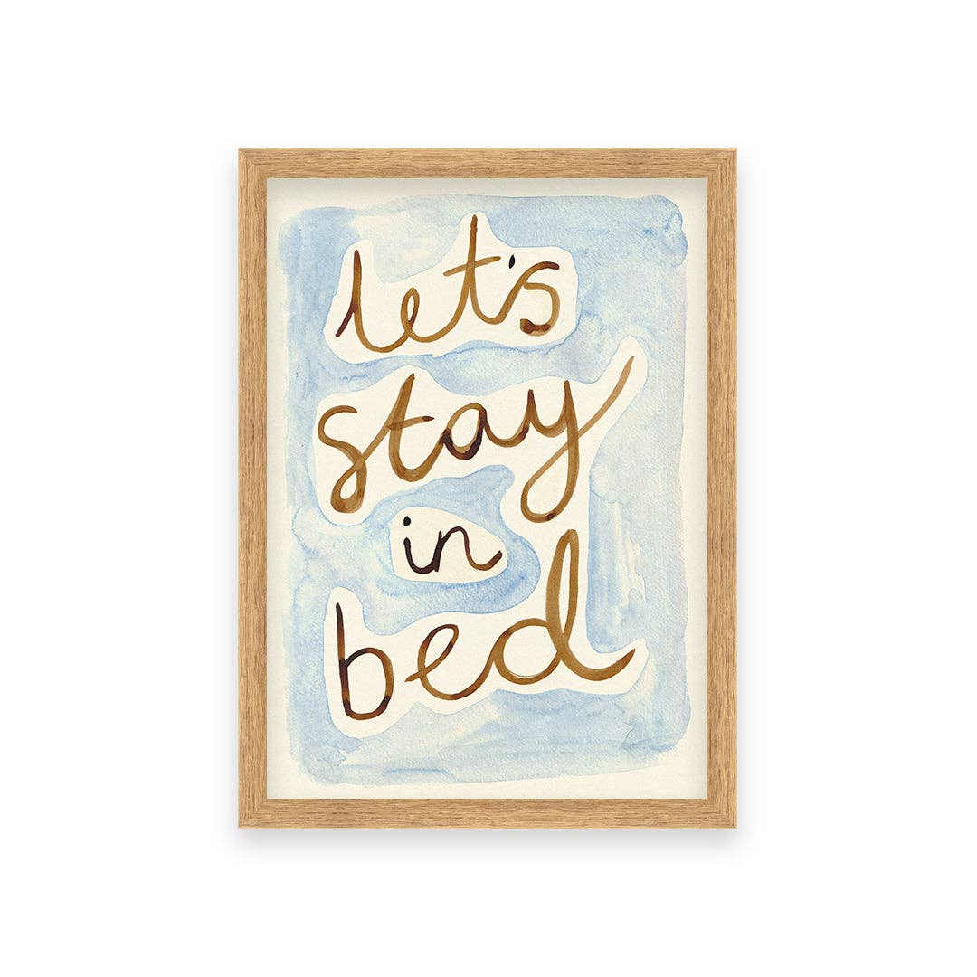 Framed artwork with 'Let's stay in bed' text on a watercolor background