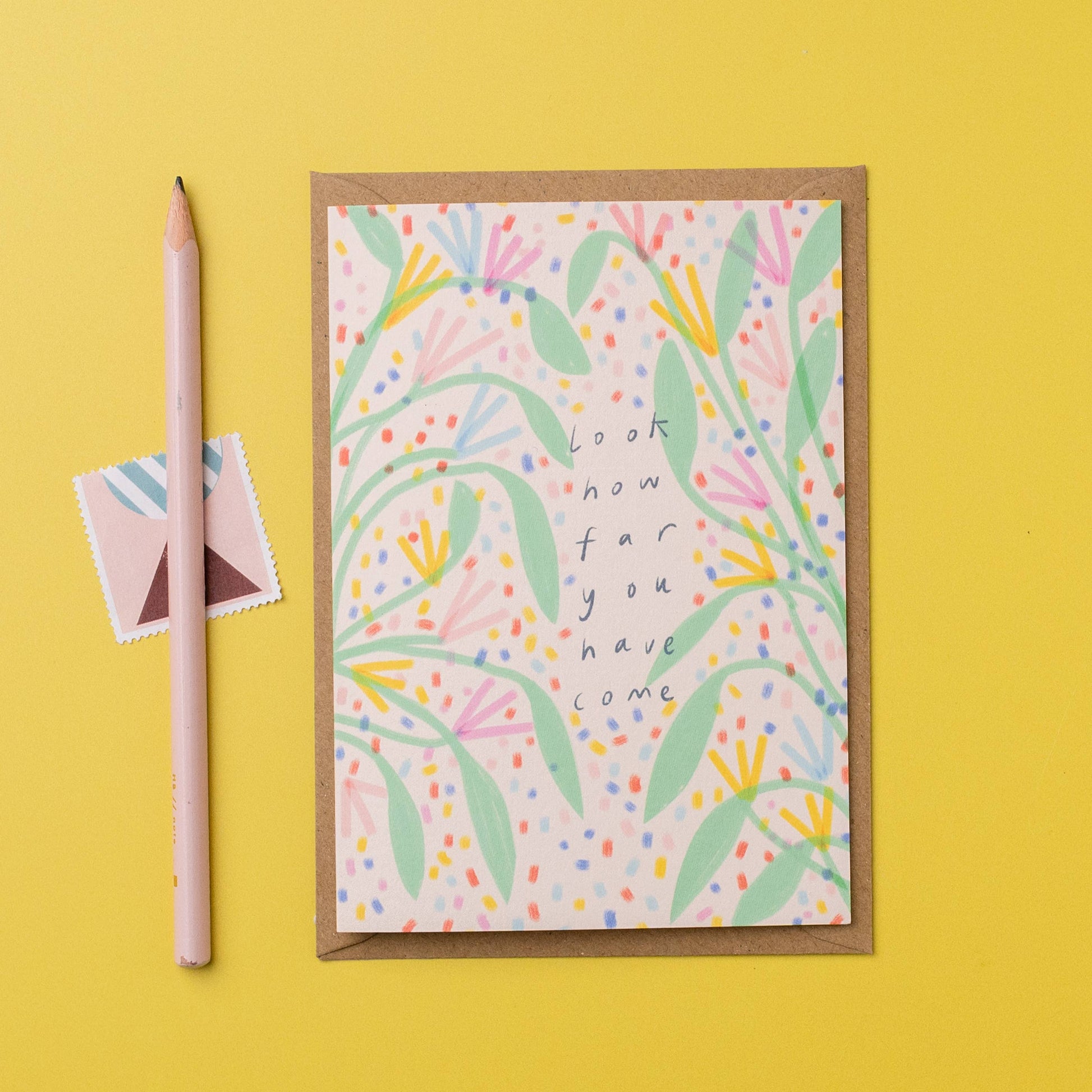 Greeting card with floral design and motivational text on a yellow background