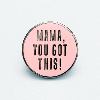 Pink enamel pin with 'Mama, you got this!' text on a light gray background