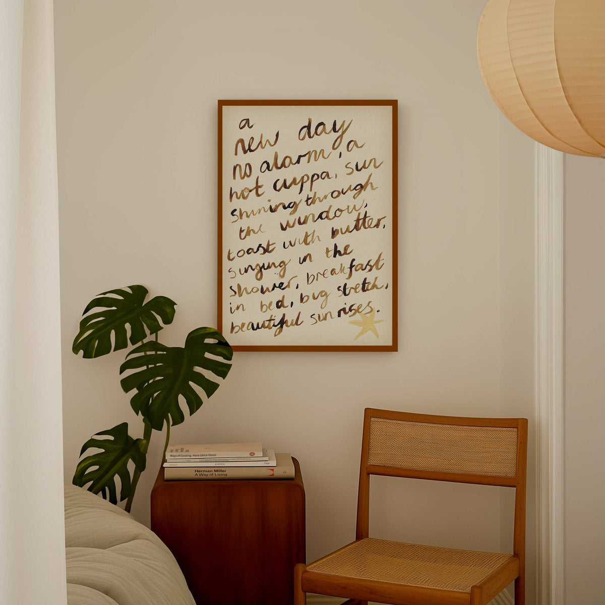 Framed poem on a wall above a wooden chair and side table with a plant.