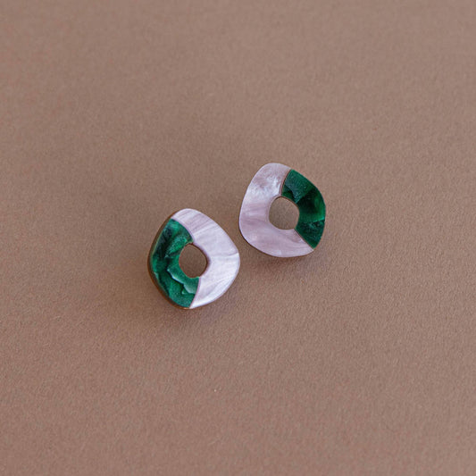 Pair of earrings with green and lilac design on a brown background