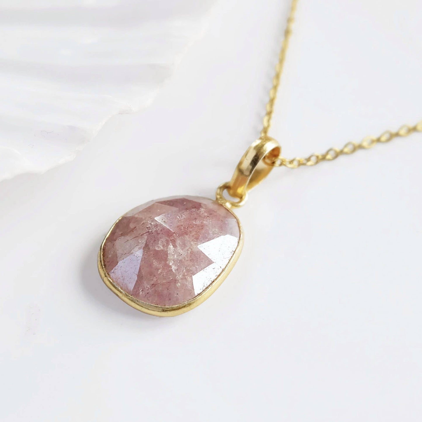 Necklace with a pink stone pendant on a white background