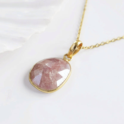 Necklace with a pink stone pendant on a white background
