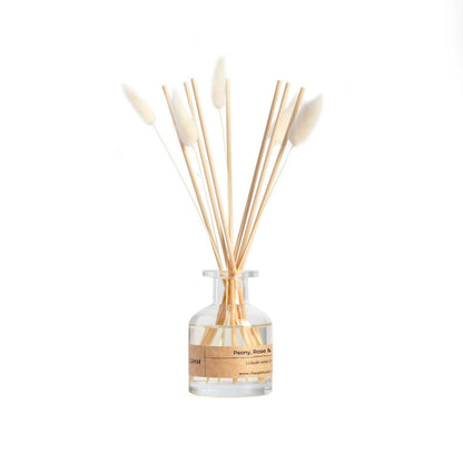 Diffuser with wooden sticks and a clear bottle on a white background