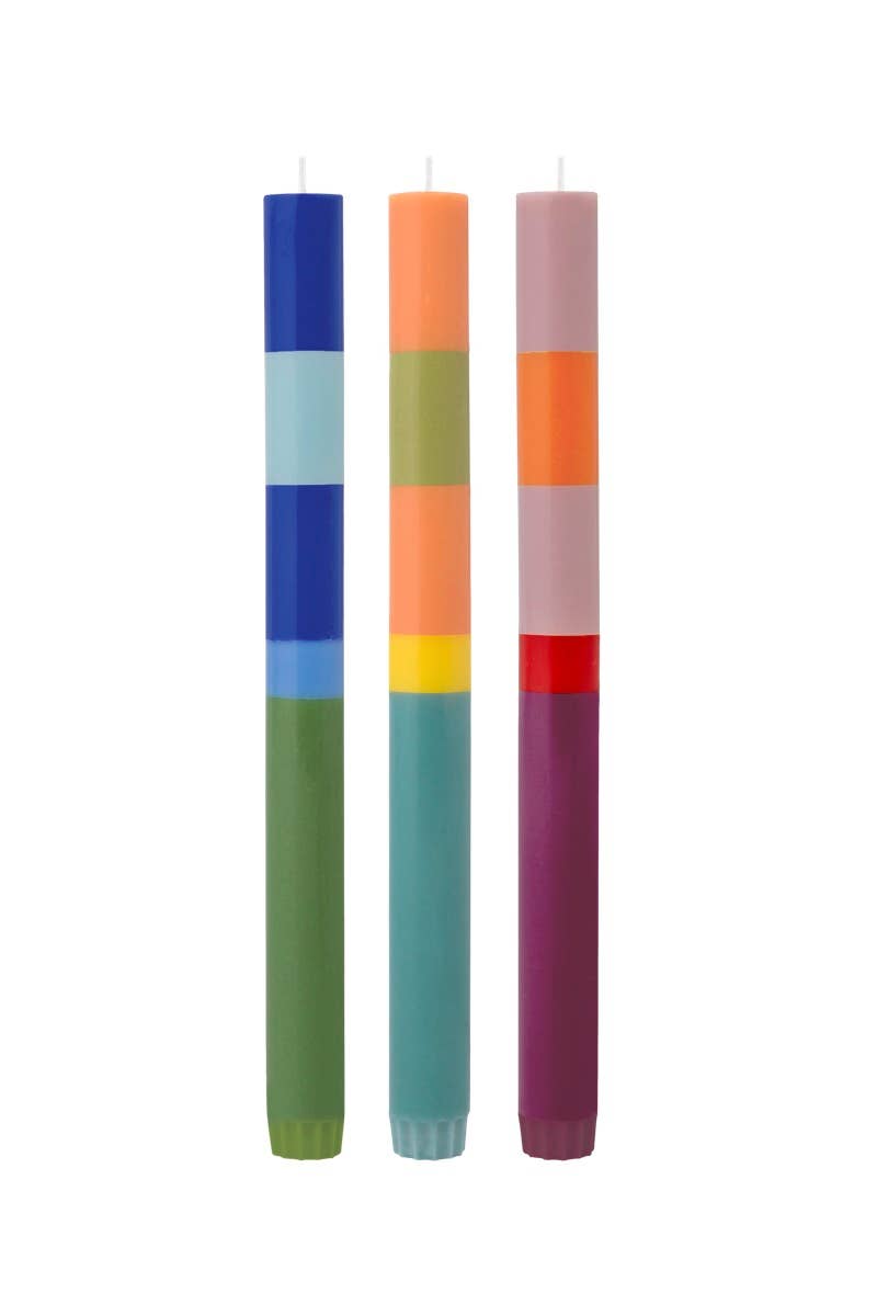 Three colorful candles with striped patterns on a white background