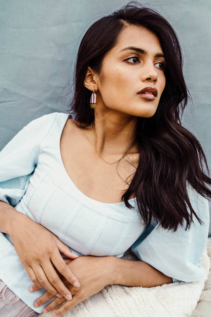 Woman wearing a light blue top with a neutral background
