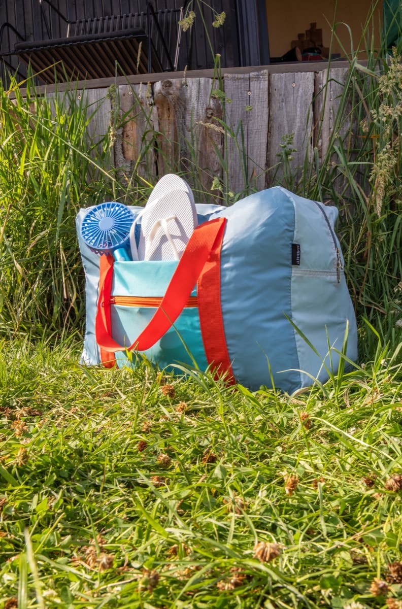 Light blue bag with red accents sitting on grass
