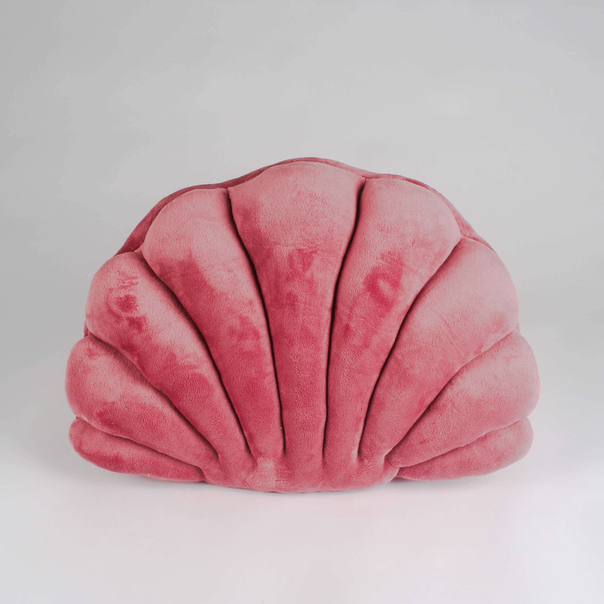Pink shell-shaped pillow on a light gray background