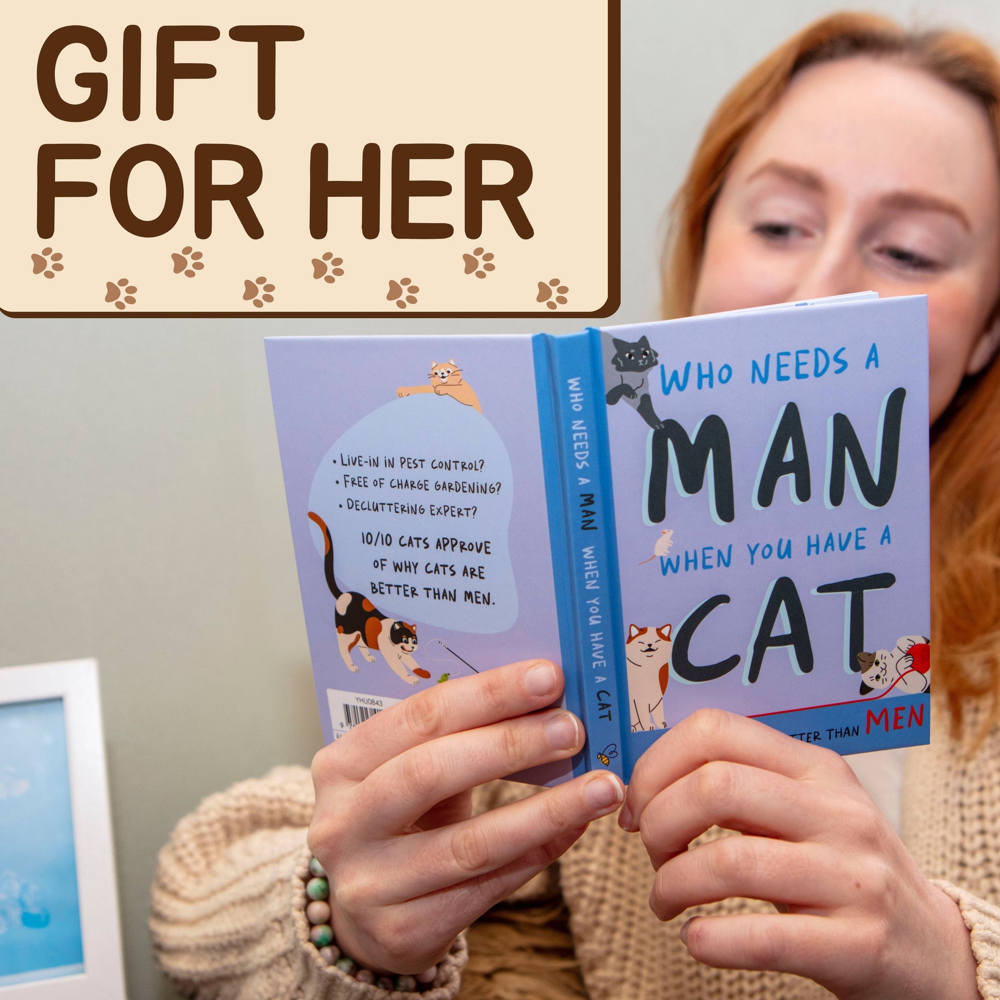 Person holding a book titled 'Who Needs a Man When You Have a Cat' with text 'Gift for Her' on a plain background.