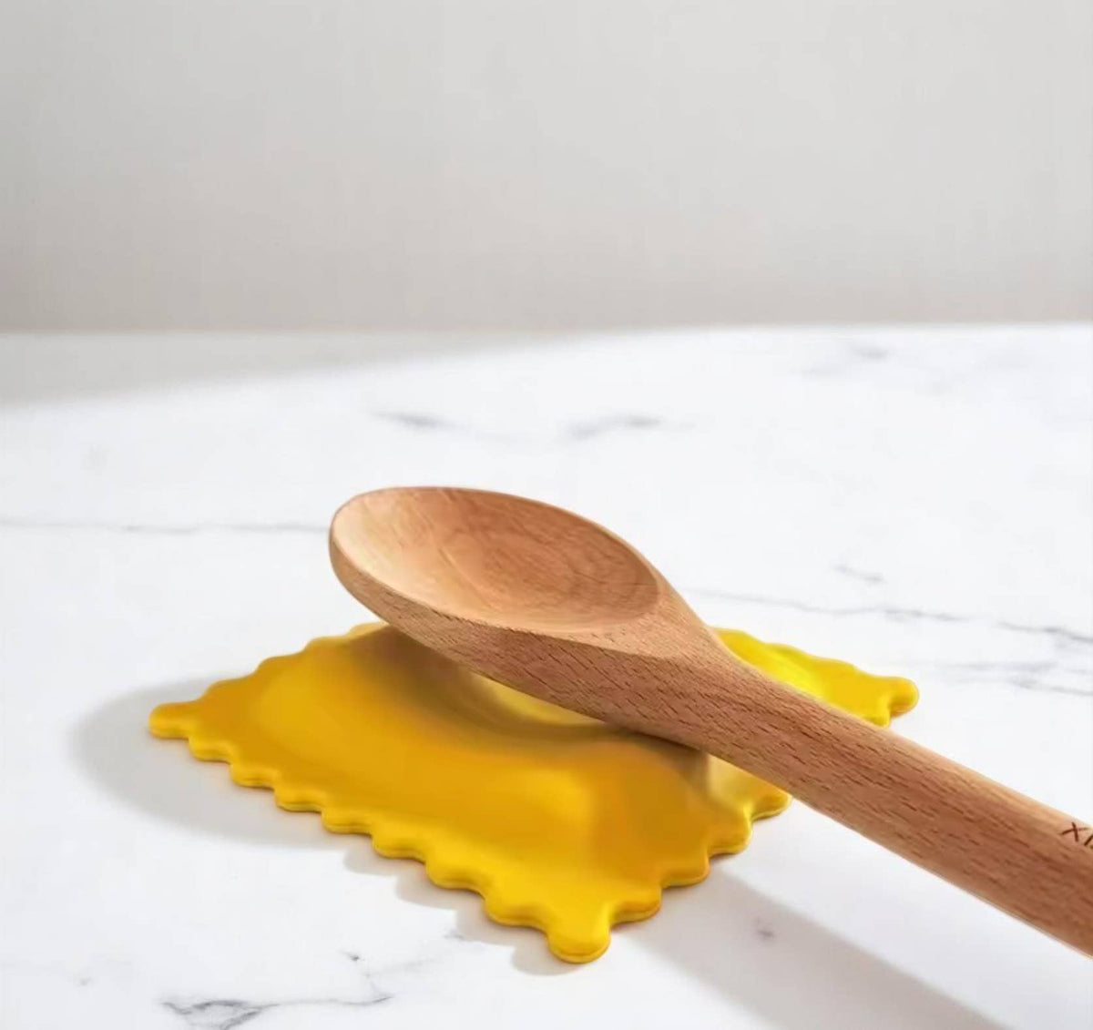 Wooden spoon on a ravioli shaped spoon rest