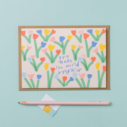 Greeting card with colorful floral design and text on a light blue background