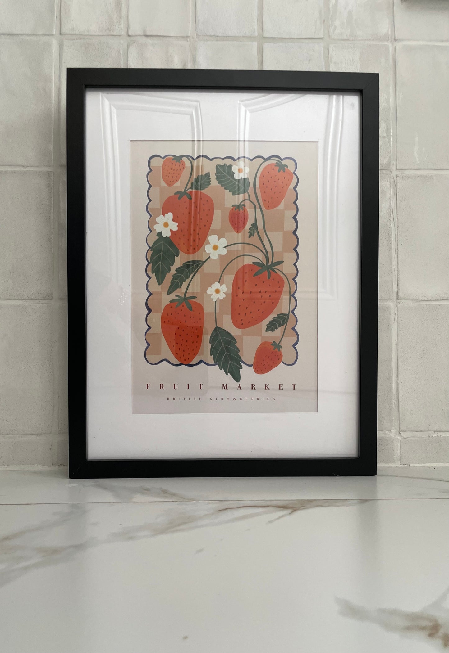 framed strawberry print in white tiled space