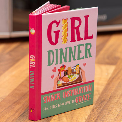 Book titled 'Girl Dinner' on a wooden surface
