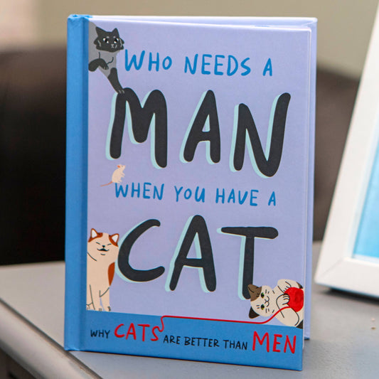 book front cover of who needs a man when you have a cat standing on table